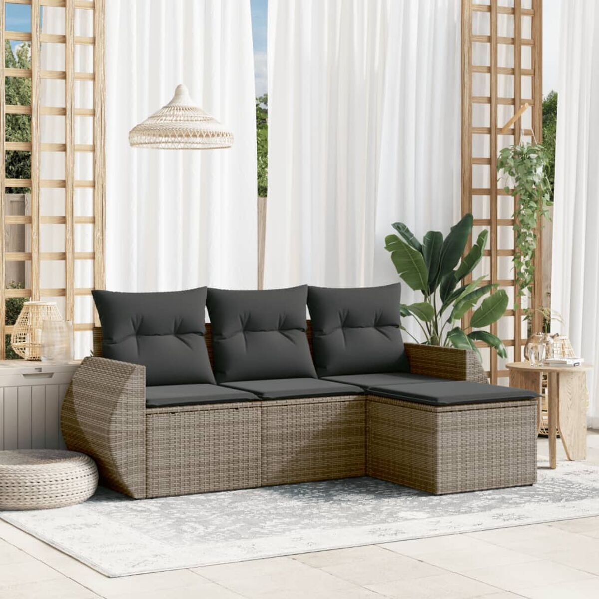 L-förmiges Outdoor-Sofa mit grauen Kissen. Ein Couchtisch und eine Pflanze davor. Weiße Vorhänge im Hintergrund.