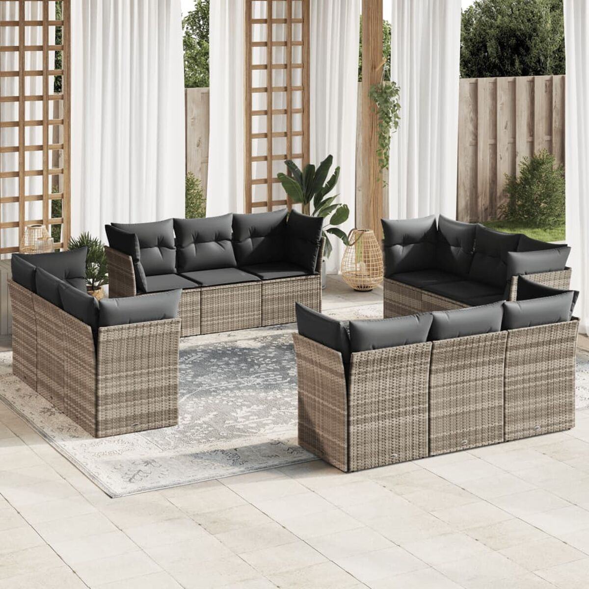 Set di sedute per esterni. Rattan beige, cuscini grigio scuro. Su patio con tappeto e tende.