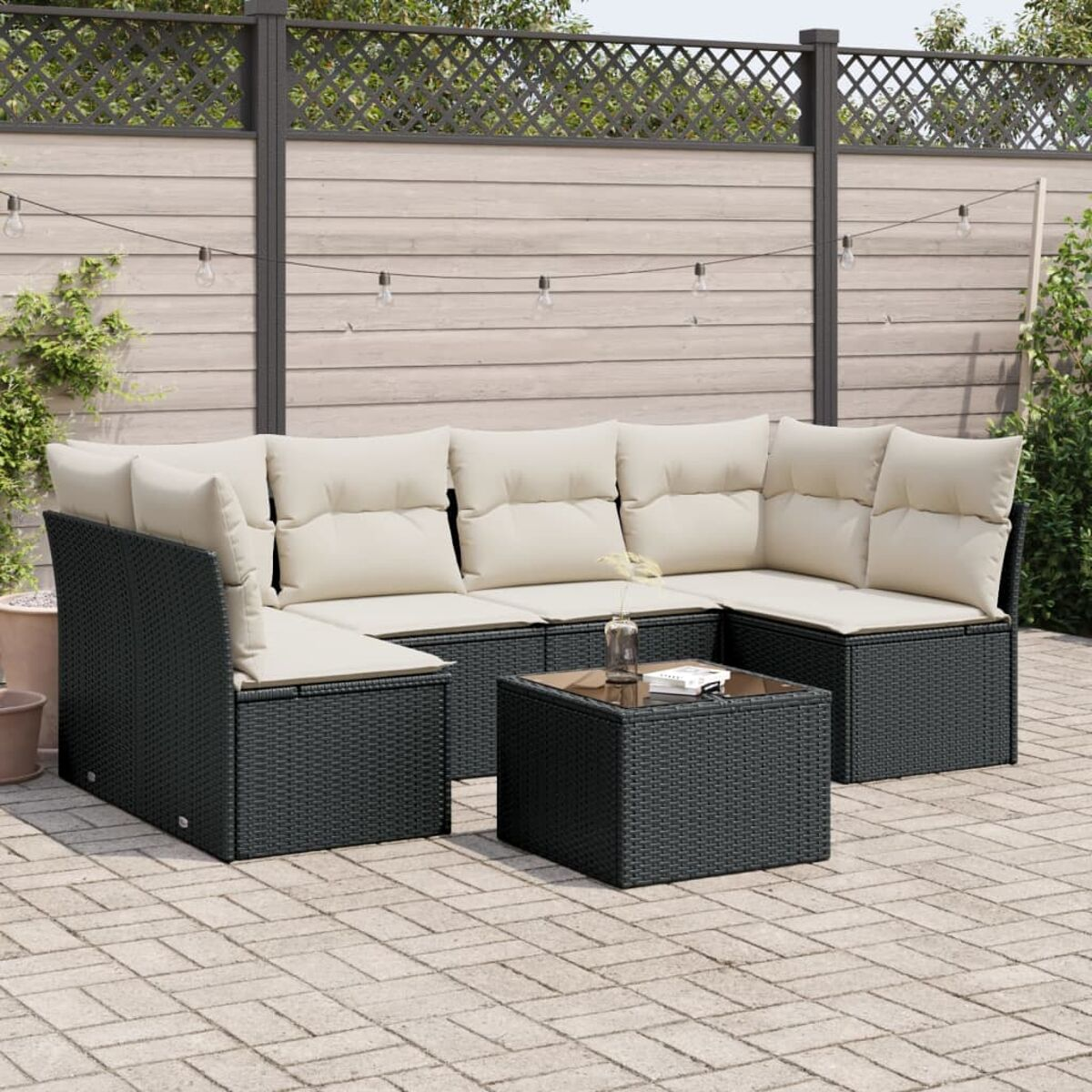 Schwarzes Outdoor-Wicker-Sofaset mit beigen Kissen und einem schwarzen Tisch.
