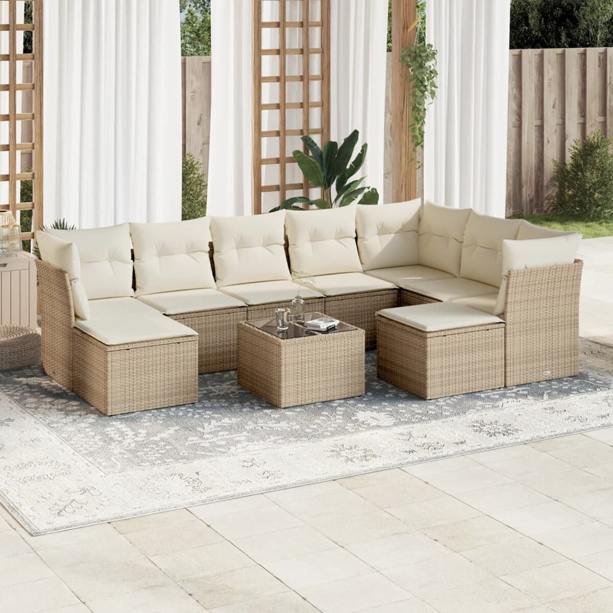 Beiges Korbsessel-Terrassenset. Enthält Sofa, Tisch und Stühle mit cremefarbenen Kissen. Vorhänge.