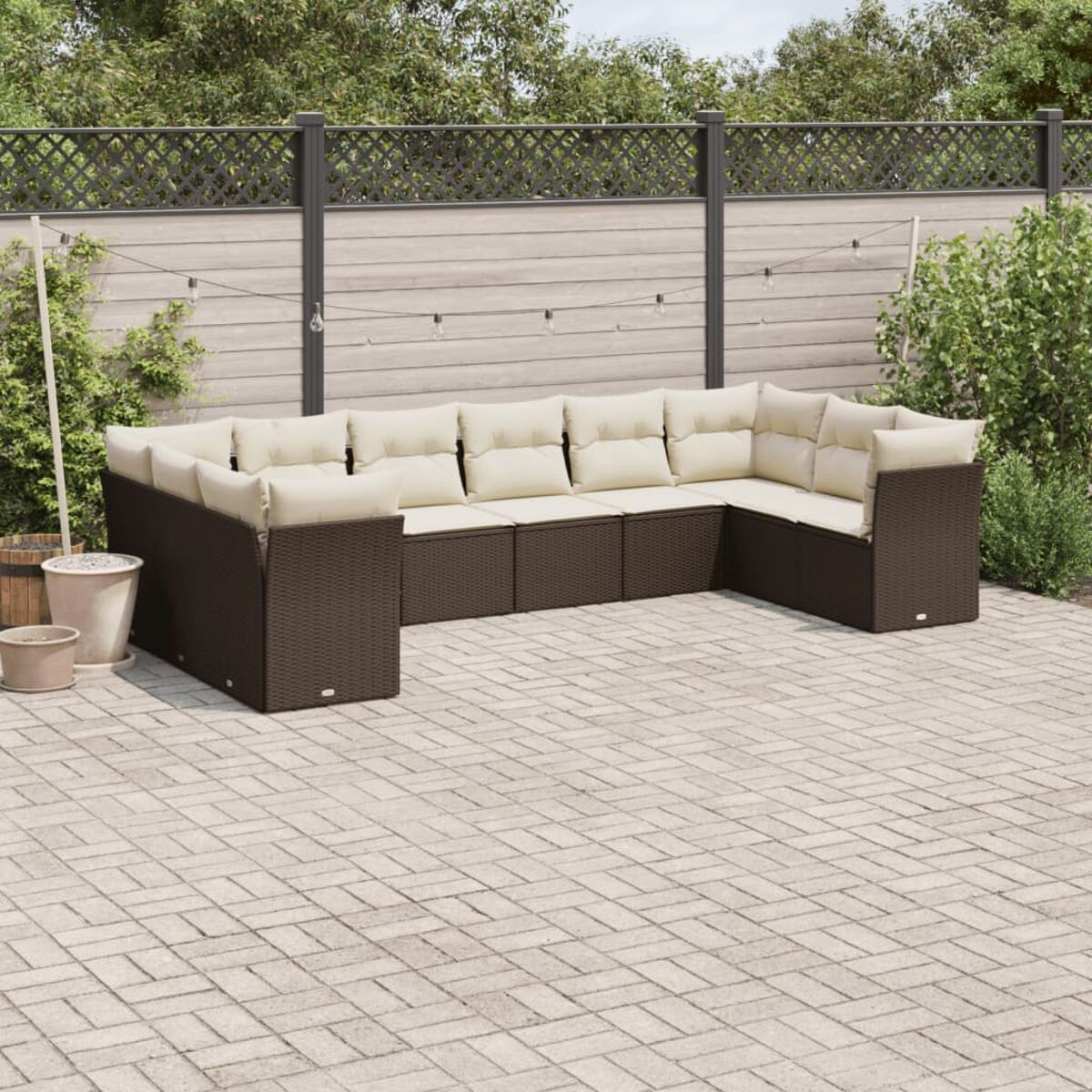 Braunes Rattan-Ecksofa mit cremefarbenen Kissen, Terrasse. Gartenmöbel.