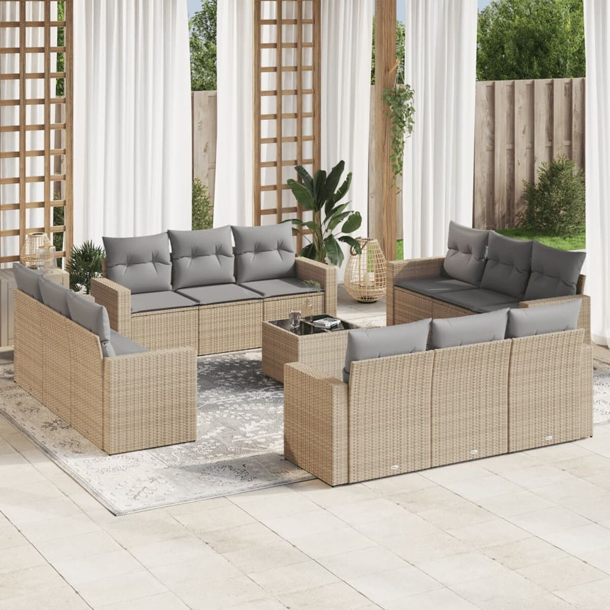 Geflochtene Gartenmöbel mit grauen Kissen und einem Teppich.