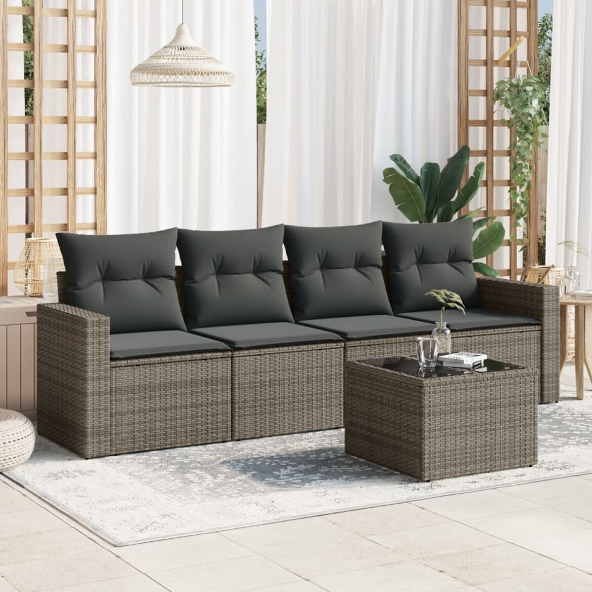 Rattansofa-Set für den Außenbereich mit grauen Kissen und einem passenden Tisch. Tag.