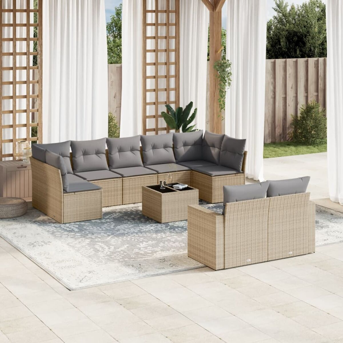Geflochtener Outdoor-Schnitt mit grauen Kissen auf einer Terrasse. Enthält einen Couchtisch und Vorhänge.