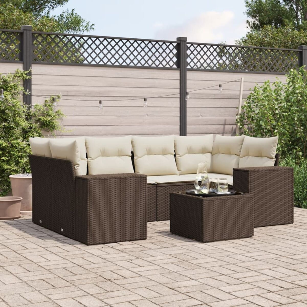 Set divano da esterno in rattan marrone su un patio pavimentato.