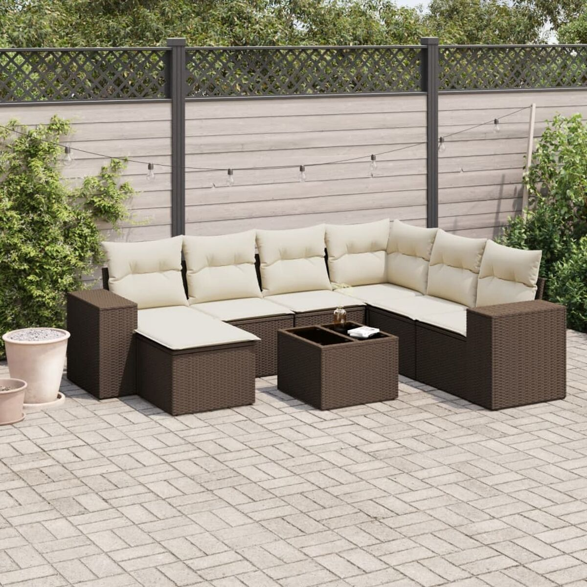 Set divano angolare da esterno marrone con tavolino, su un patio in mattoni.