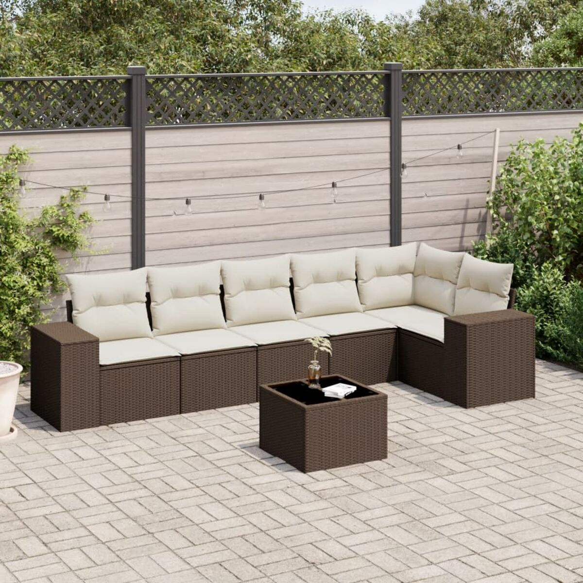 Dunkelbraunes Gartenmöbelset aus Korbgeflecht. Ecksofa, Tisch und Stuhl. Backstein-Terrasse.
