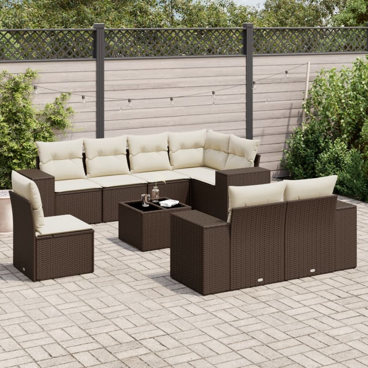 Set di mobili da esterno in vimini marrone con cuscini color crema, tavolino e patio in mattoni.