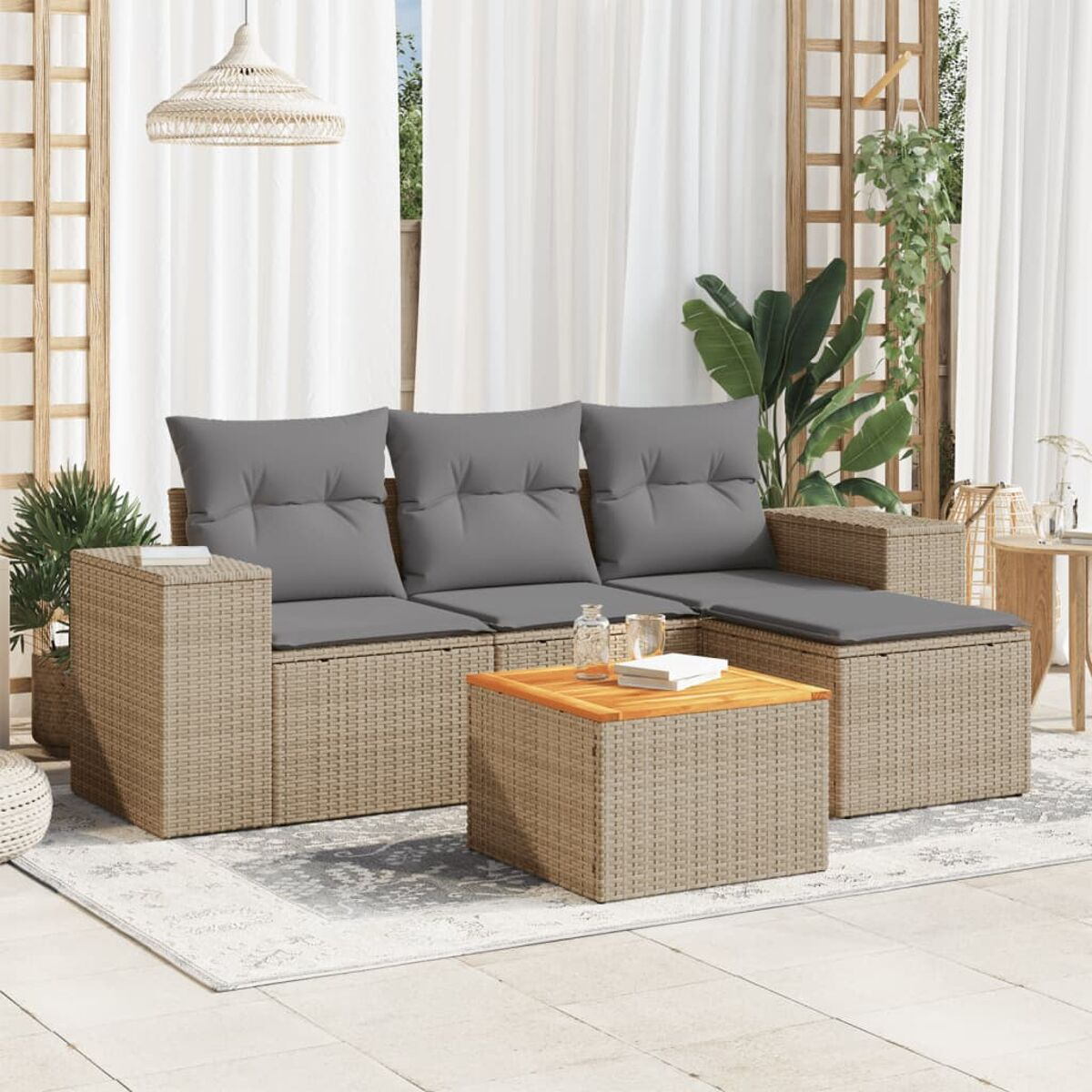 Rattansofa-Set mit grauen Kissen und einem Holztisch auf einer Terrasse mit weißen Vorhängen.