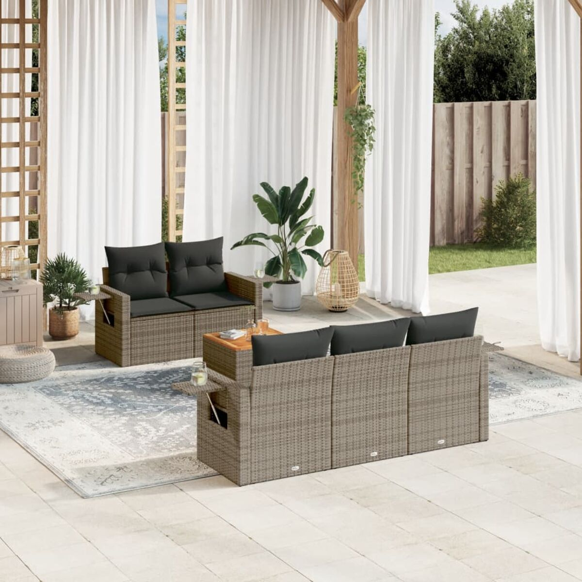Garnitur mit Sofa, zwei Stühlen und Tisch. Beige Korbgeflecht und schwarze Kissen.