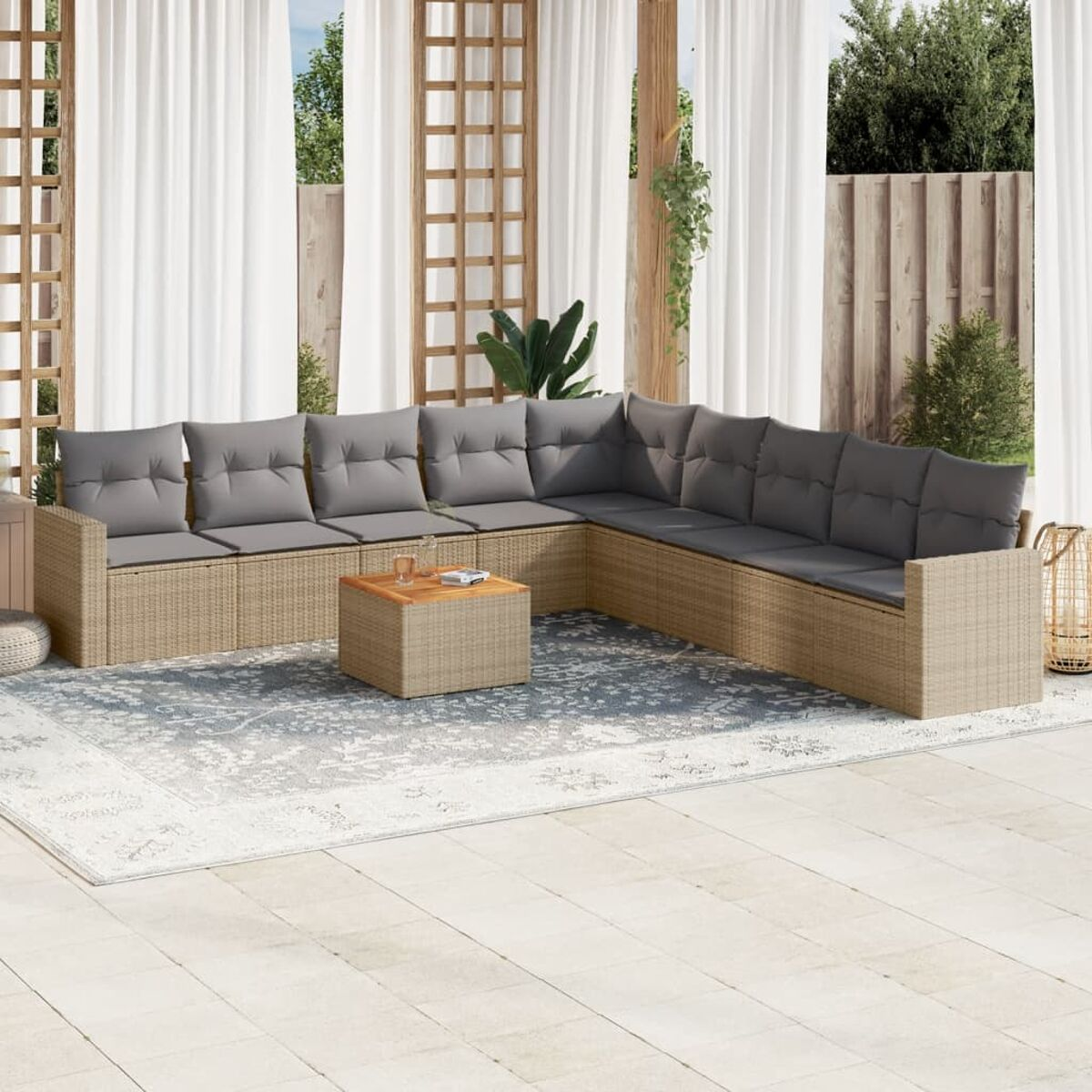 Outdoor-Wicker-Sofagarnitur, graue Kissen, Holztisch, Terrasseneinstellung. Weiße Vorhänge, Pflanzen.