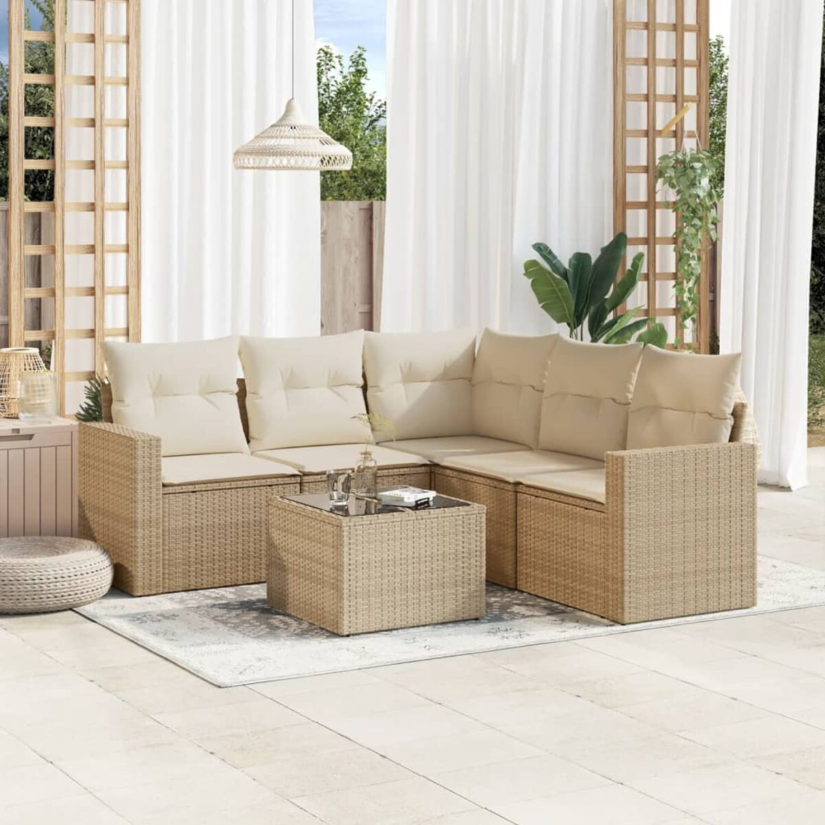 Ein geflochtenes Ecksofa mit einem Couchtisch und Kissen auf einer Terrasse.
