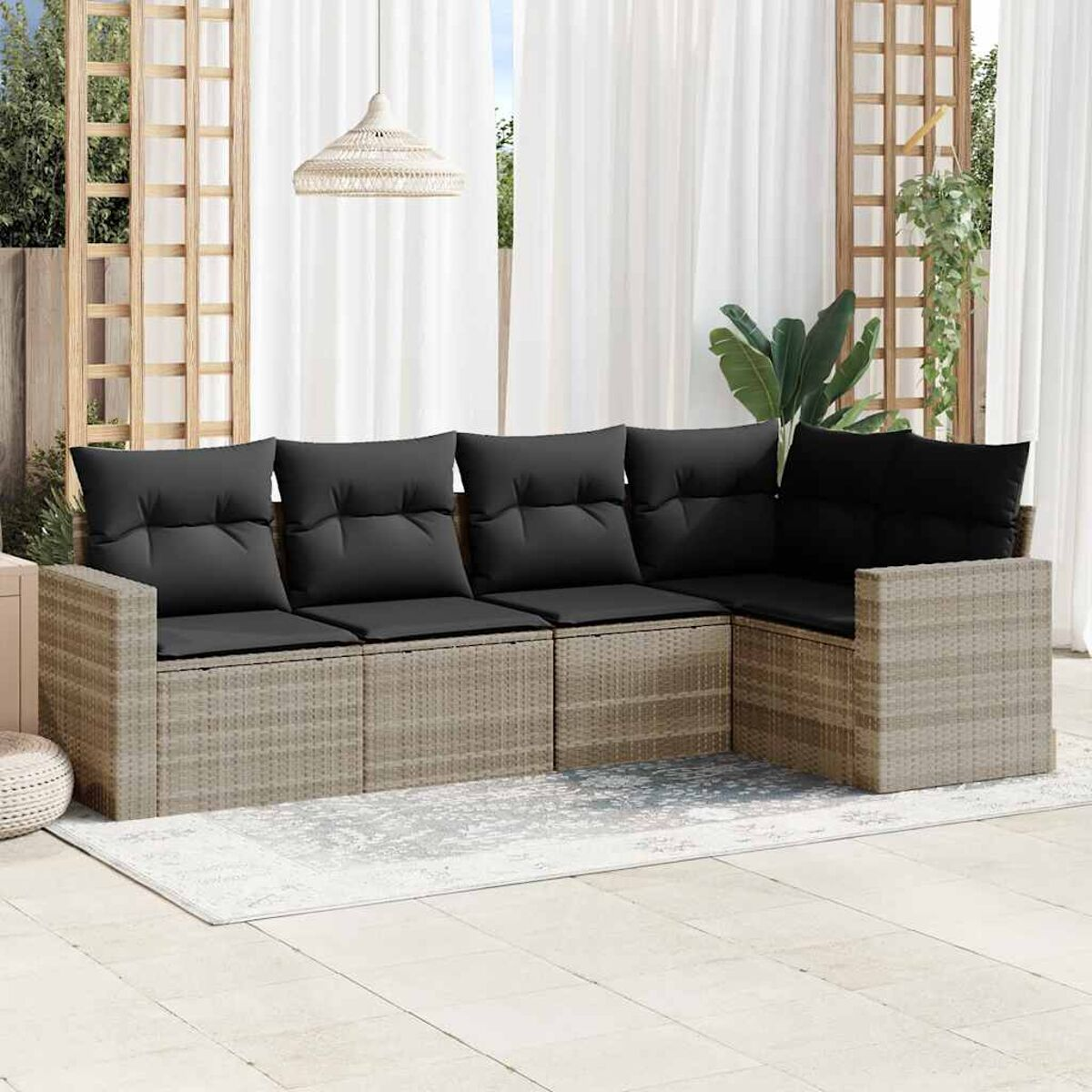 Divano componibile per esterni con cuscini neri. Struttura a trama beige.