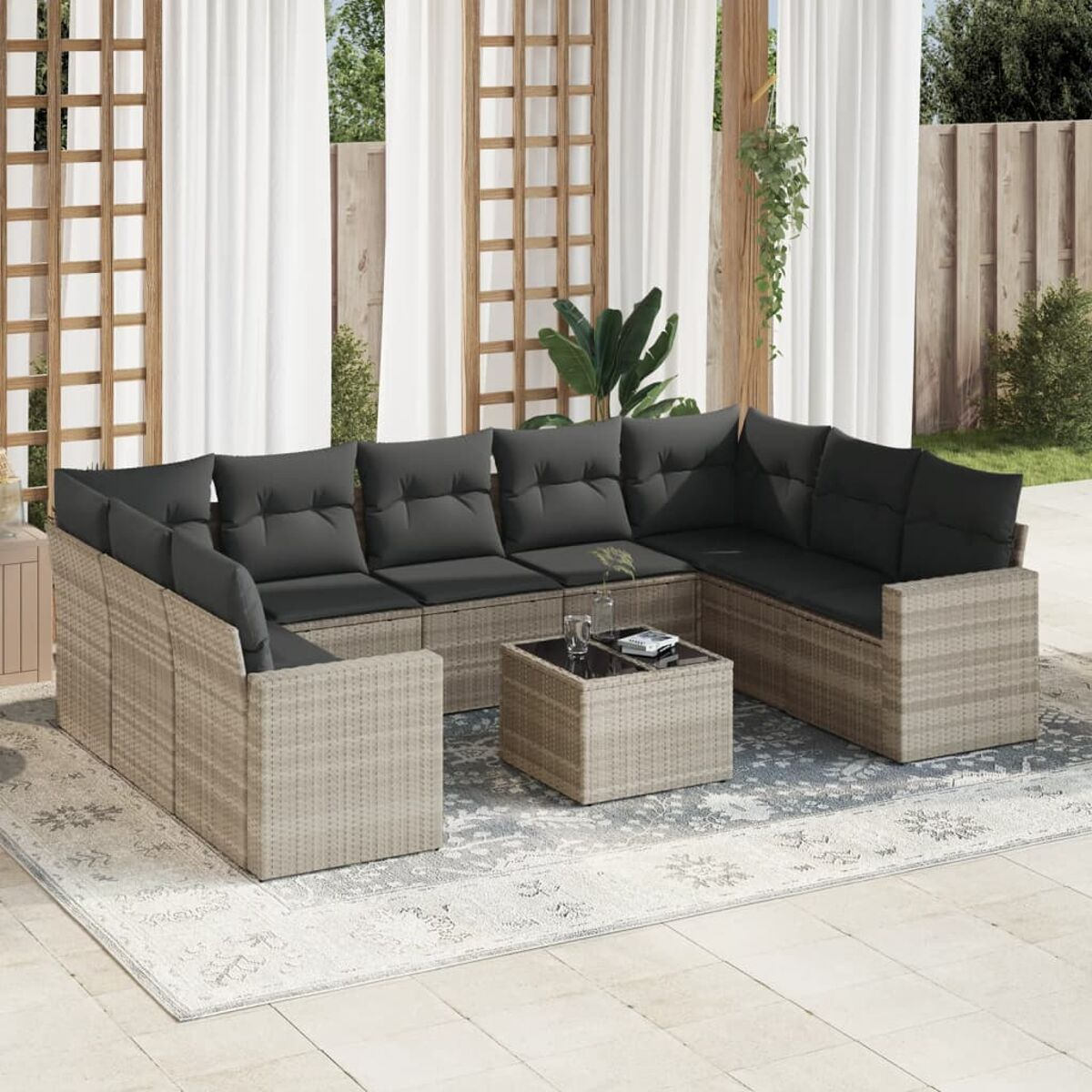 Beiges Ecksofa aus Korbgeflecht mit grauen Kissen und einem Couchtisch mit Glasplatte auf einem Teppich.