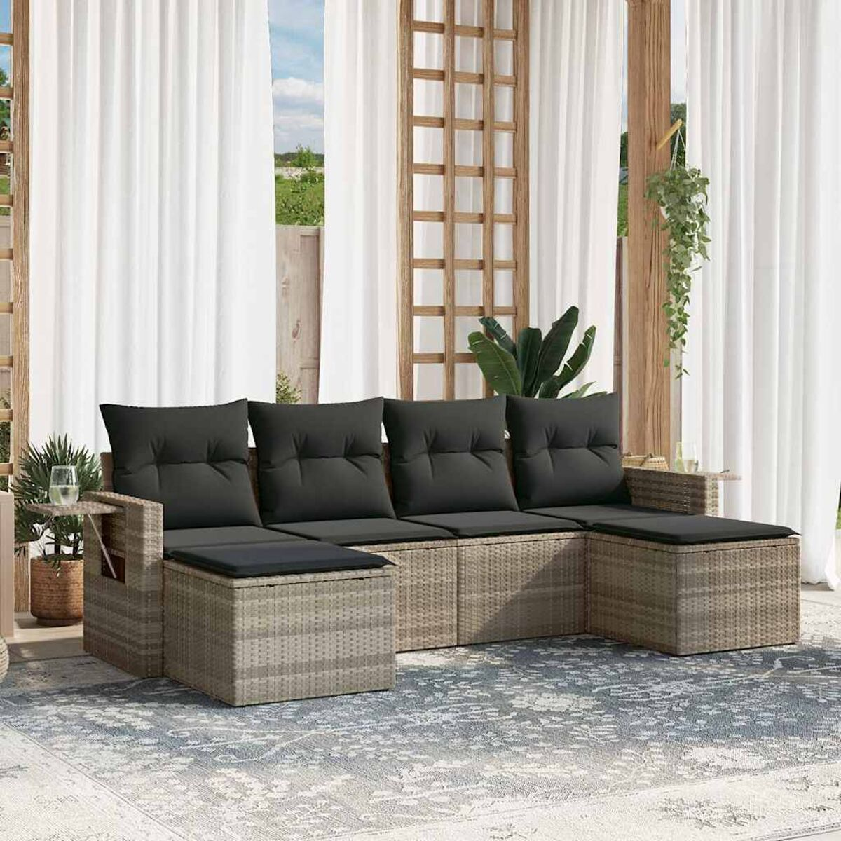 Ecksofa für den Außenbereich mit grauen Kissen und Ottomanen auf einem Teppich mit Pflanzen.
