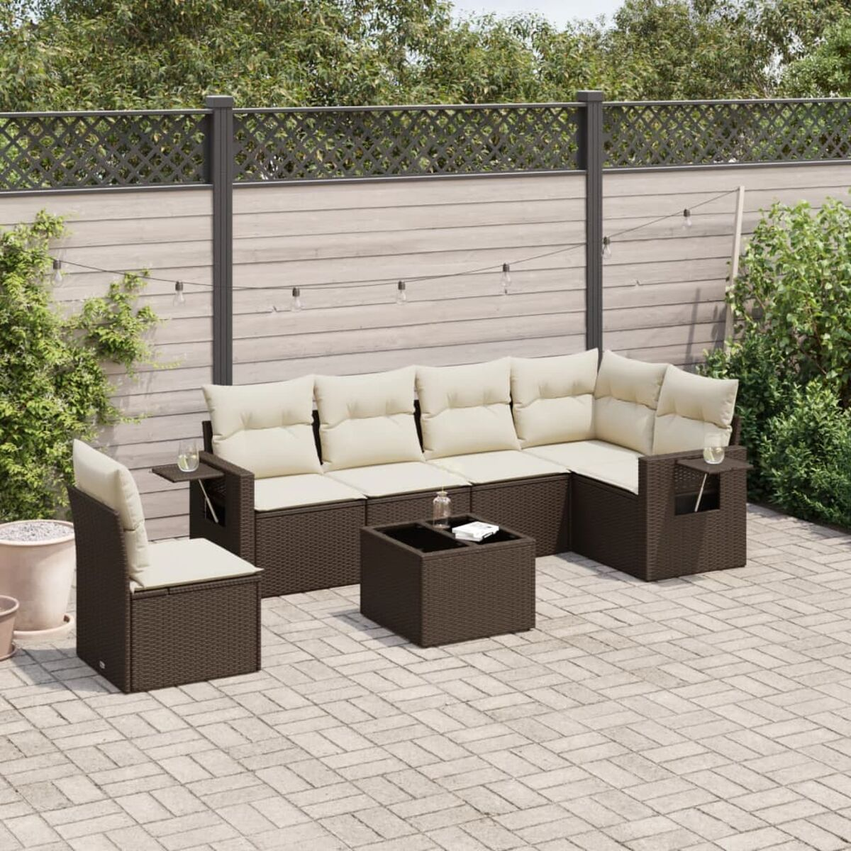 Set di mobili da patio in vimini per esterni. Include divano, sedia e tavolo con cuscini.