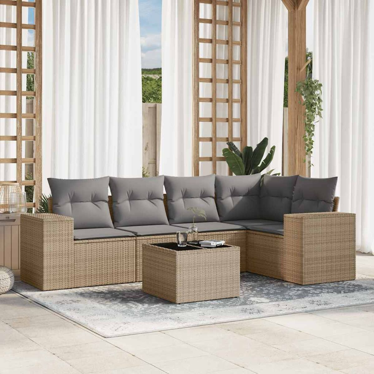 Ein beiges Rattan-Ecksofa mit grauen Kissen und einem Couchtisch auf einem gemusterten Teppich.