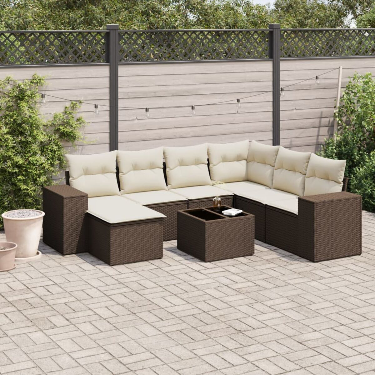 Gartenmöbel. Braunes Korbgeflecht mit cremefarbenen Kissen. Holztisch.