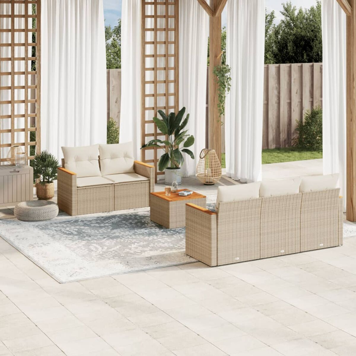 Szene im Freien mit Sofa, Stühlen und Tisch. Die Möbel sind aus Korbgeflecht und haben beige Kissen.