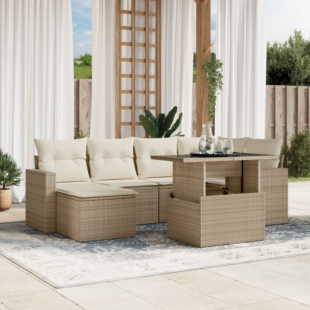 Mobili da esterno in vimini con cuscini beige e tavolo sollevabile.