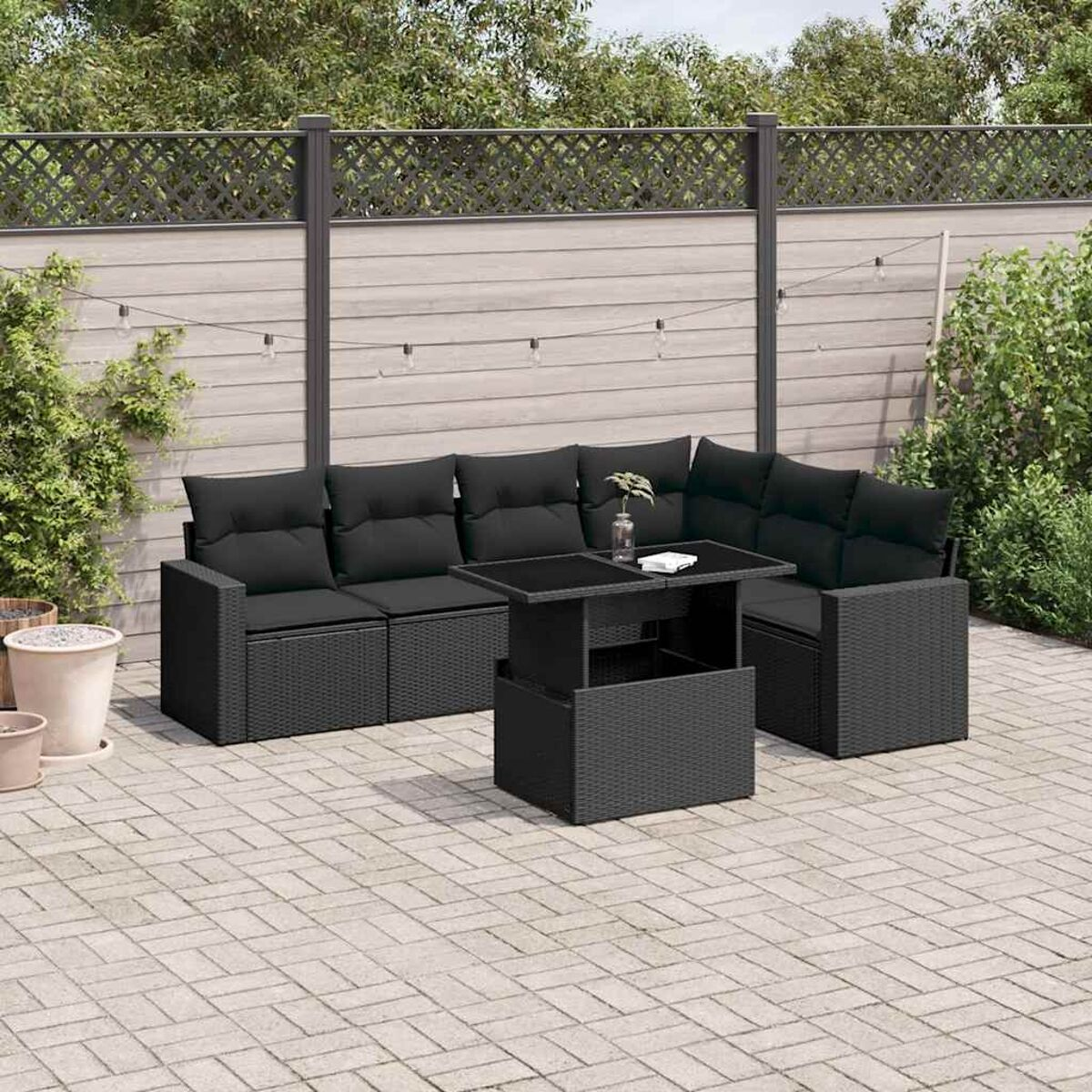 Schwarzes Ecksofa und Tisch-Set aus Korbgeflecht mit schwarzen Kissen, Outdoor-Patio-Setting.