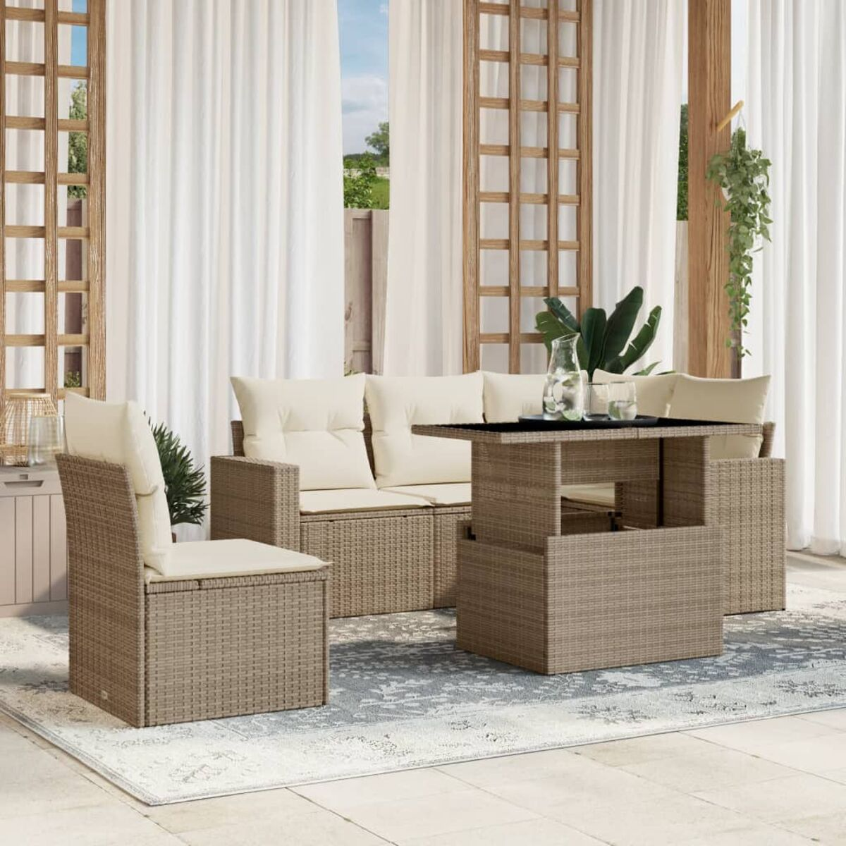 Divano componibile da esterno in rattan beige con cuscini beige, un tavolo e una sedia, su un tappeto fantasia.