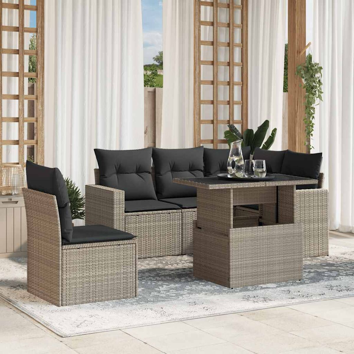 Graue Rattan-Sofagarnitur mit schwarzen Kissen, einem anhebenden Couchtisch und Außenbereich.