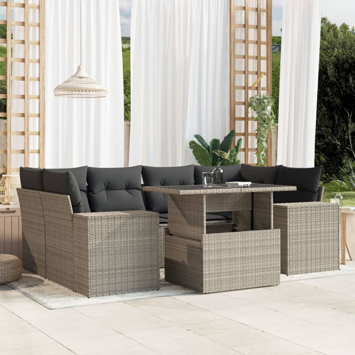 Sitzgruppe im Freien mit hellbraunem Korbmöbel, Tisch und Stühlen auf einer Terrasse.