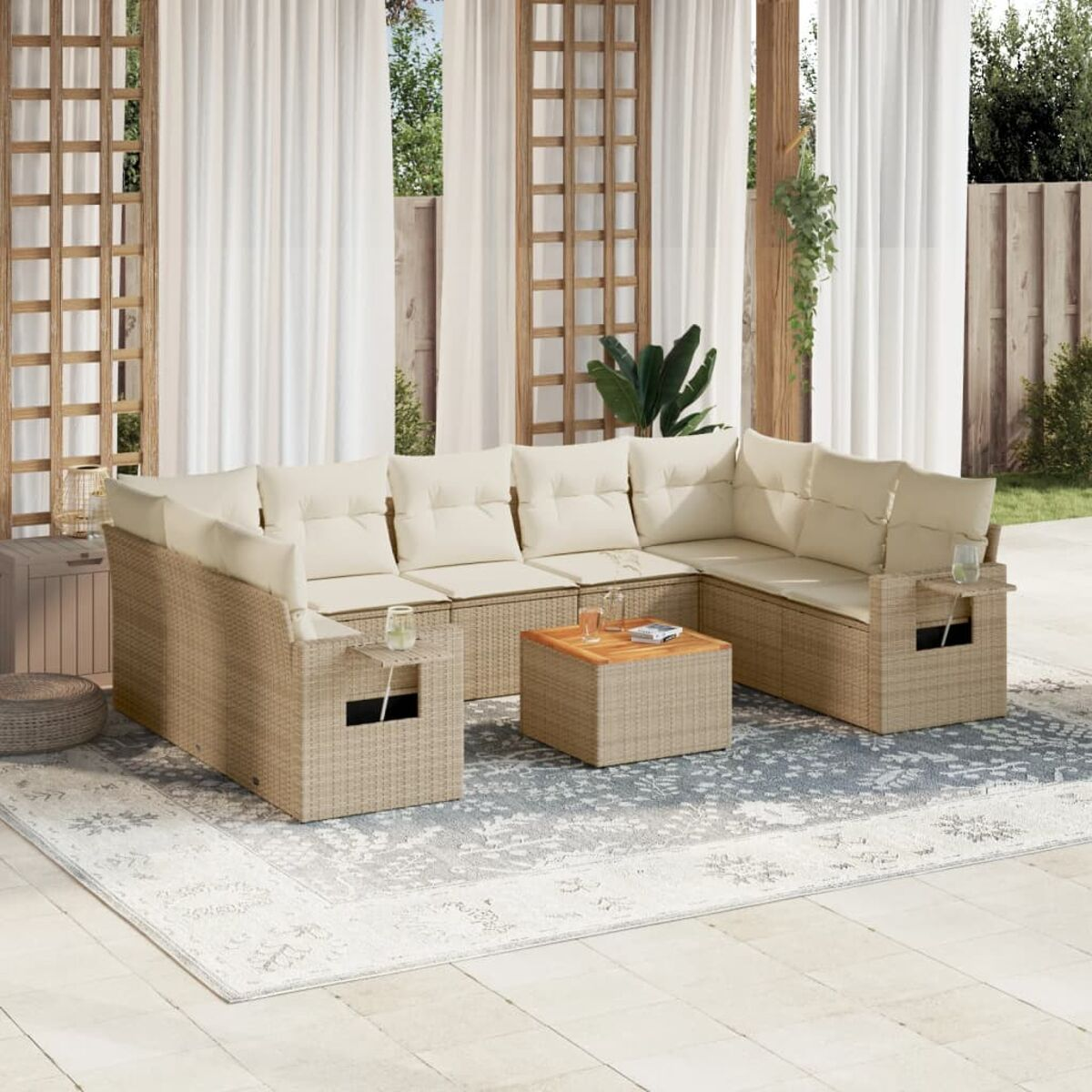 Set divani in vimini per esterni con cuscini beige e tappeto.
