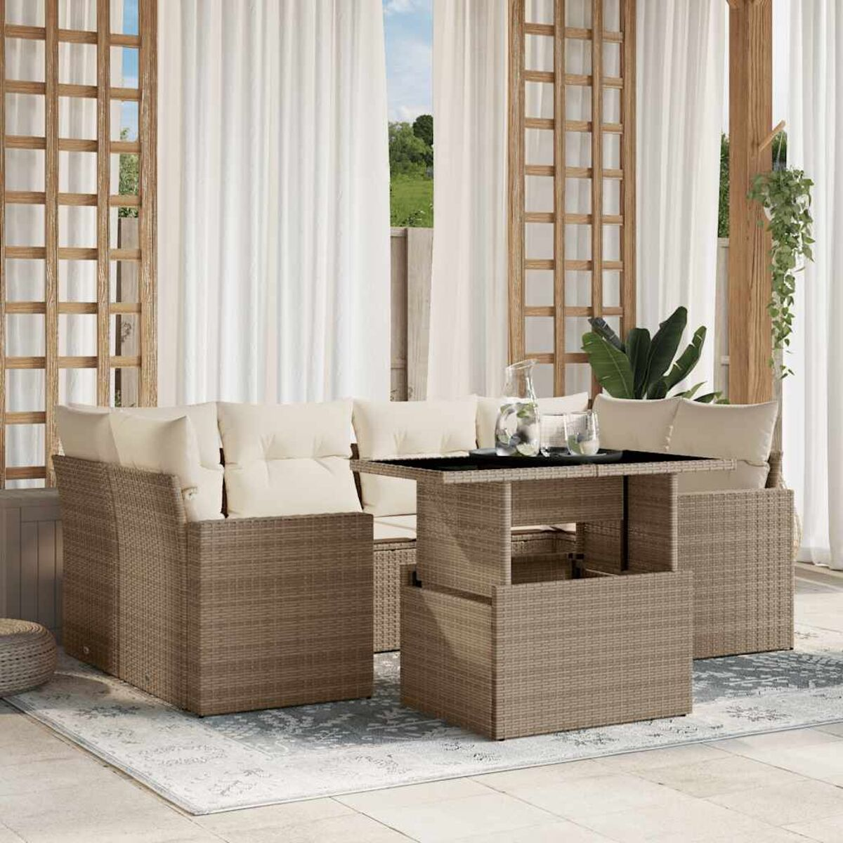 Beige geflochtene Outdoor-Eckcouch mit cremefarbenen Kissen und einem Tisch. Terrasse mit weißen Vorhängen.