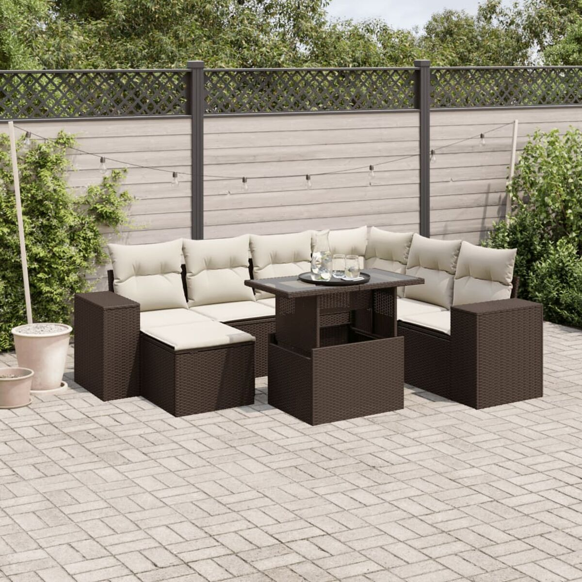 Outdoor-Rattan-Sofagarnitur mit Tisch. Das Set hat ein Sofa, einen Tisch und zwei Stühle. Die Szene ist eine Terrasse.