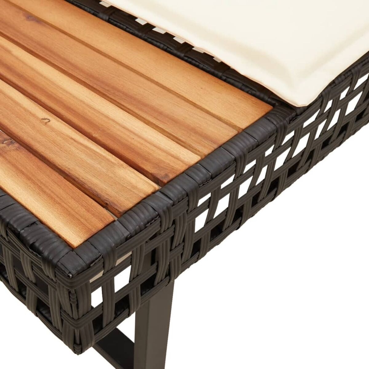 Primo piano di una panca in rattan intrecciato marrone scuro con piano in legno e cuscino crema.