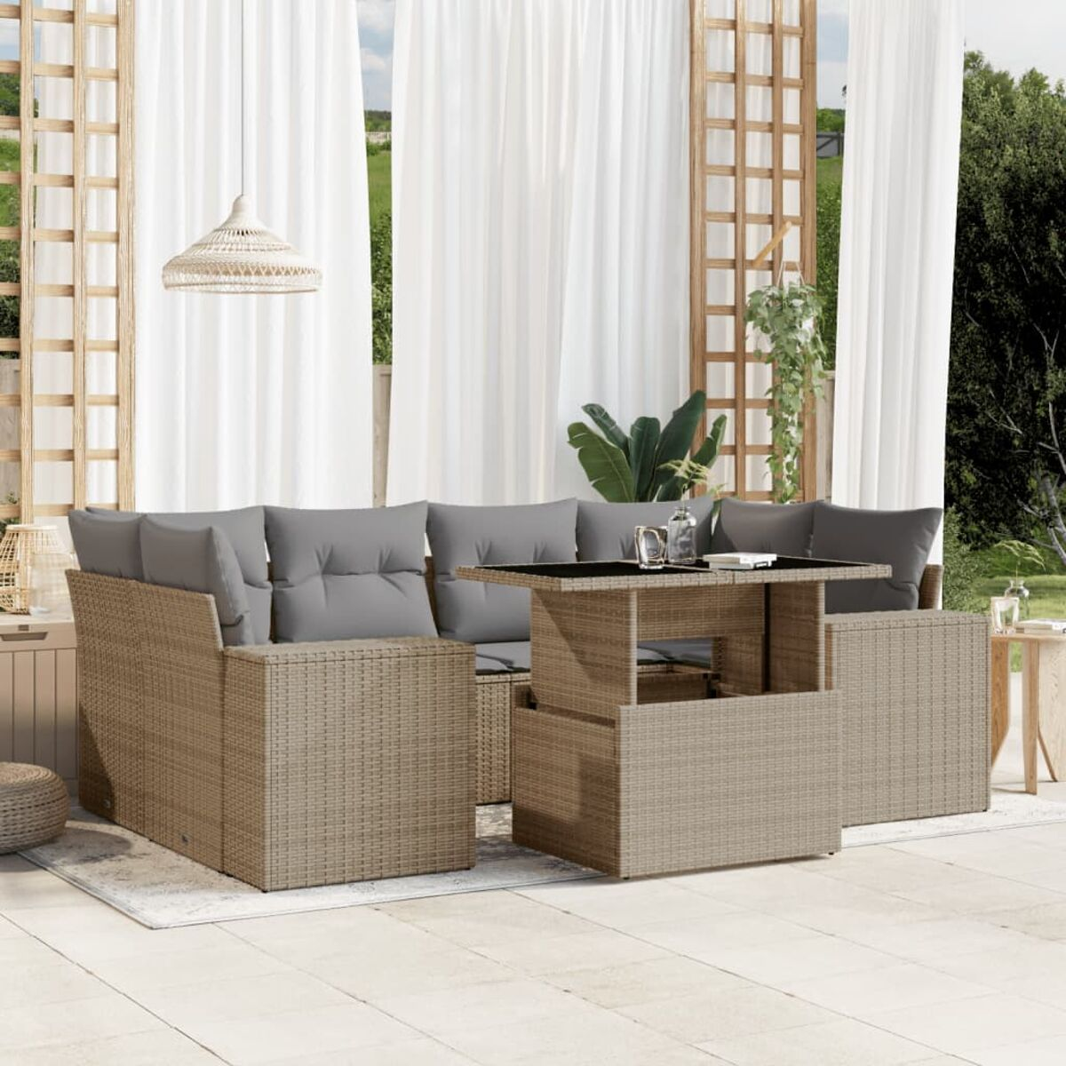 Rattan-Set im Freien mit grauen Kissen und Hubtisch. Beiger Teppich, weiße Vorhänge und Pflanzen im Hintergrund.