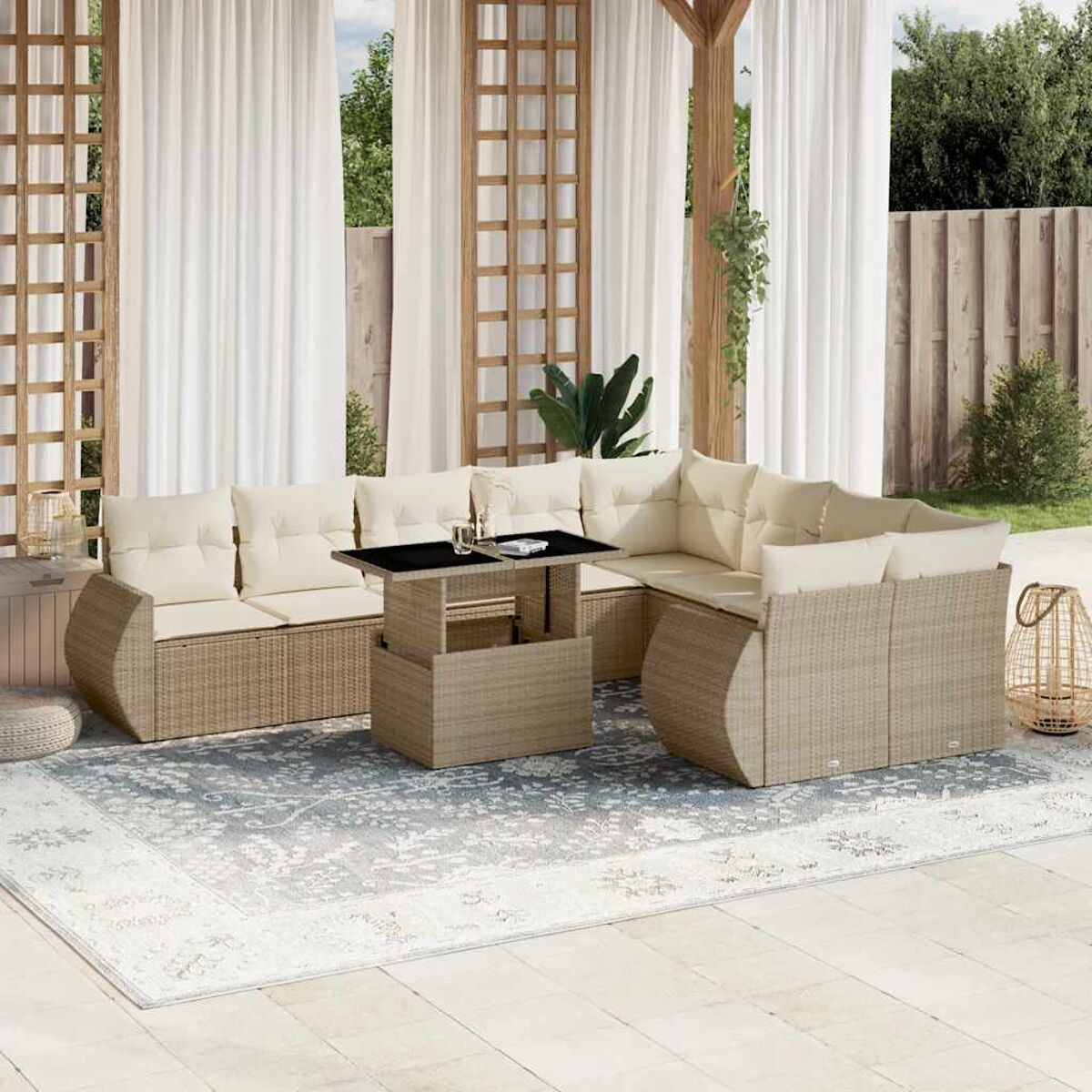 Set di sedute da esterno in vimini con cuscini color crema su un patio con tappeto e tavolo.