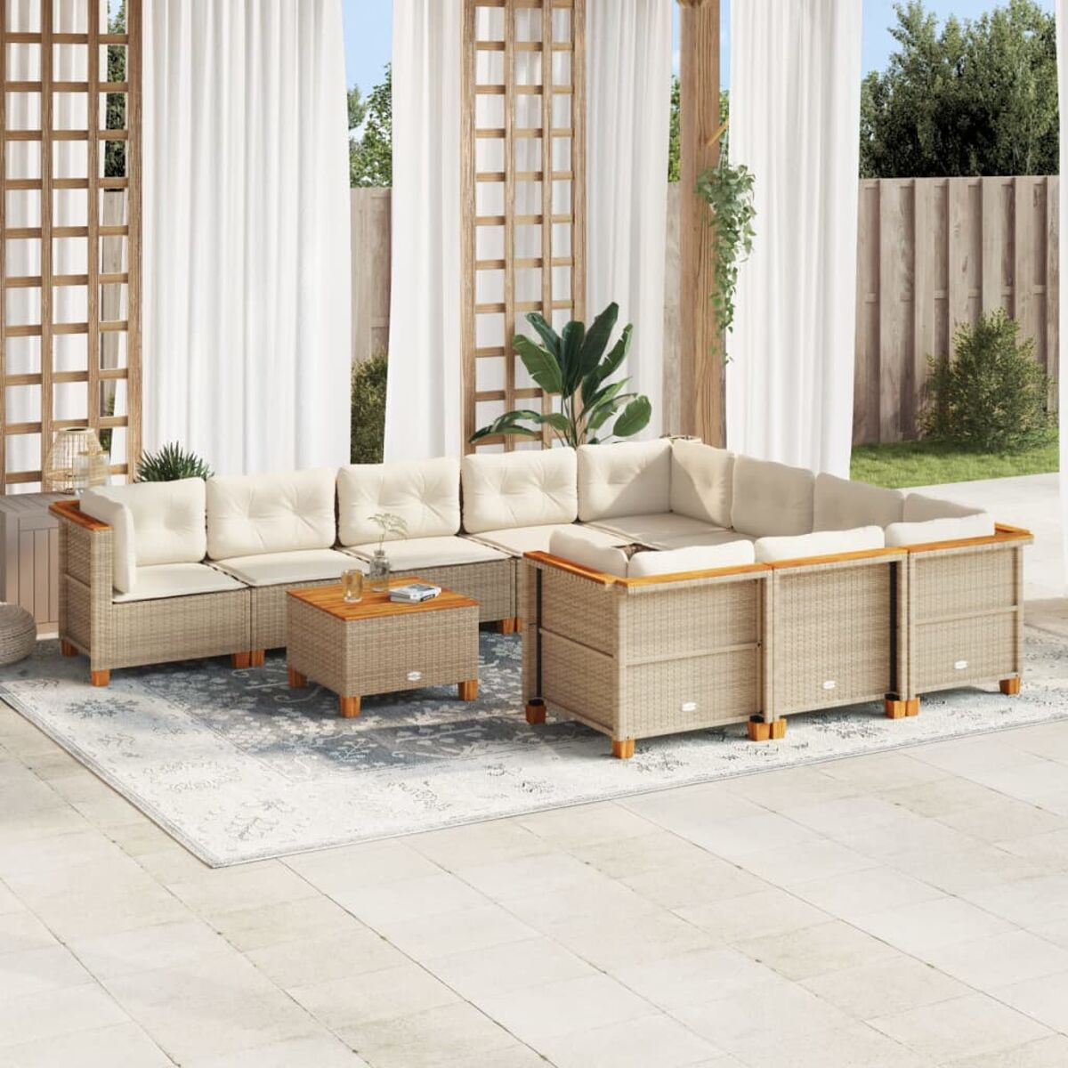 Set divano in rattan con cuscini bianchi, tavolino, tappeto. Braccioli in legno, ambiente patio.