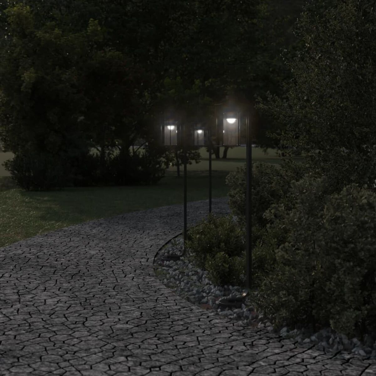 Sentiero con ciottoli, che conduce a tre lampade illuminate. Alberi scuri sullo sfondo.