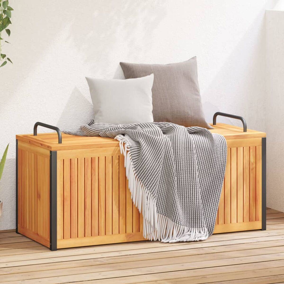 Outdoor-Aufbewahrungsbank aus Holz mit Kissen und einer Decke auf einem Holzdeck.