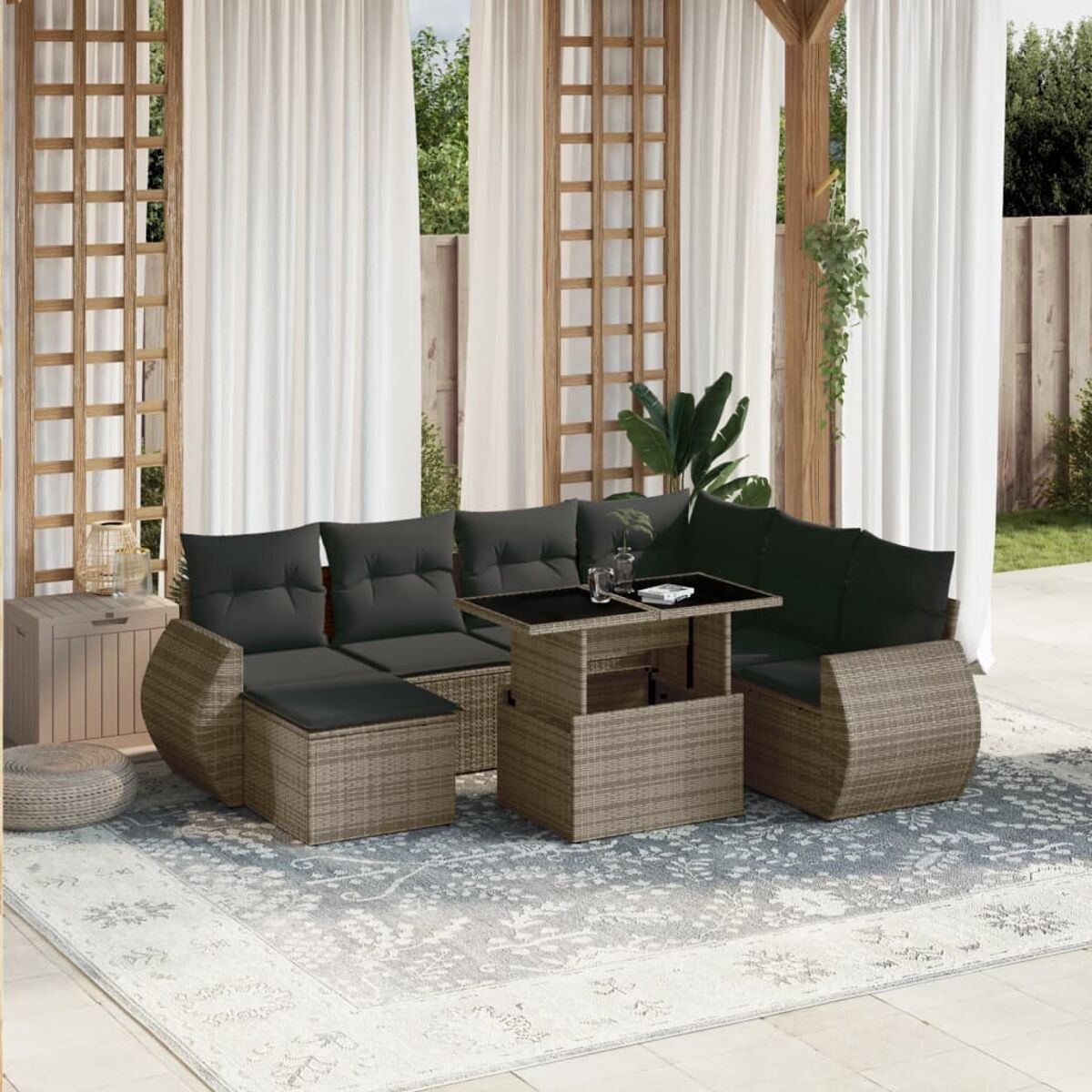 Rattan Outdoor-Ecksofa mit schwarzem Tisch, weißen Vorhängen und einem Teppich.