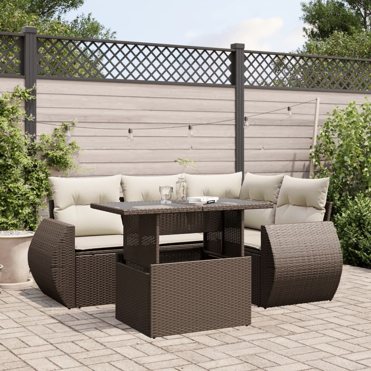 Brauner Outdoor-Eckbereich aus Korbgeflecht mit beigen Kissen und Tisch.