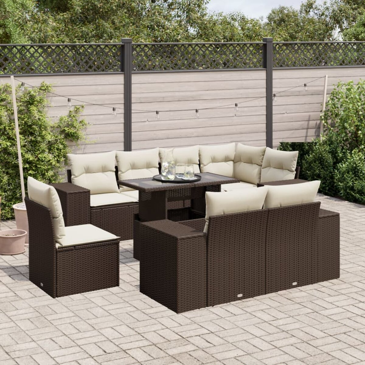 Braunes Wicker-Outdoor-Sofa mit cremefarbenen Kissen. Inklusive Tisch und Stuhl. Ziegelterrasse.