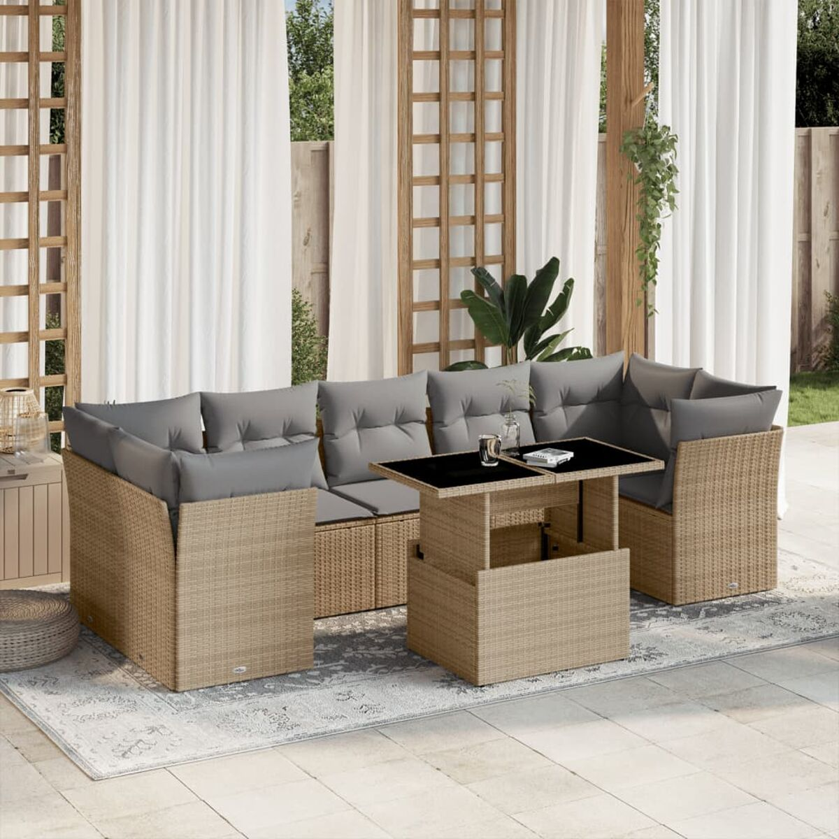 Outdoor-Wicker-Sofa mit grauen Kissen. Tisch in der Mitte. Weiße Vorhänge im Hintergrund.
