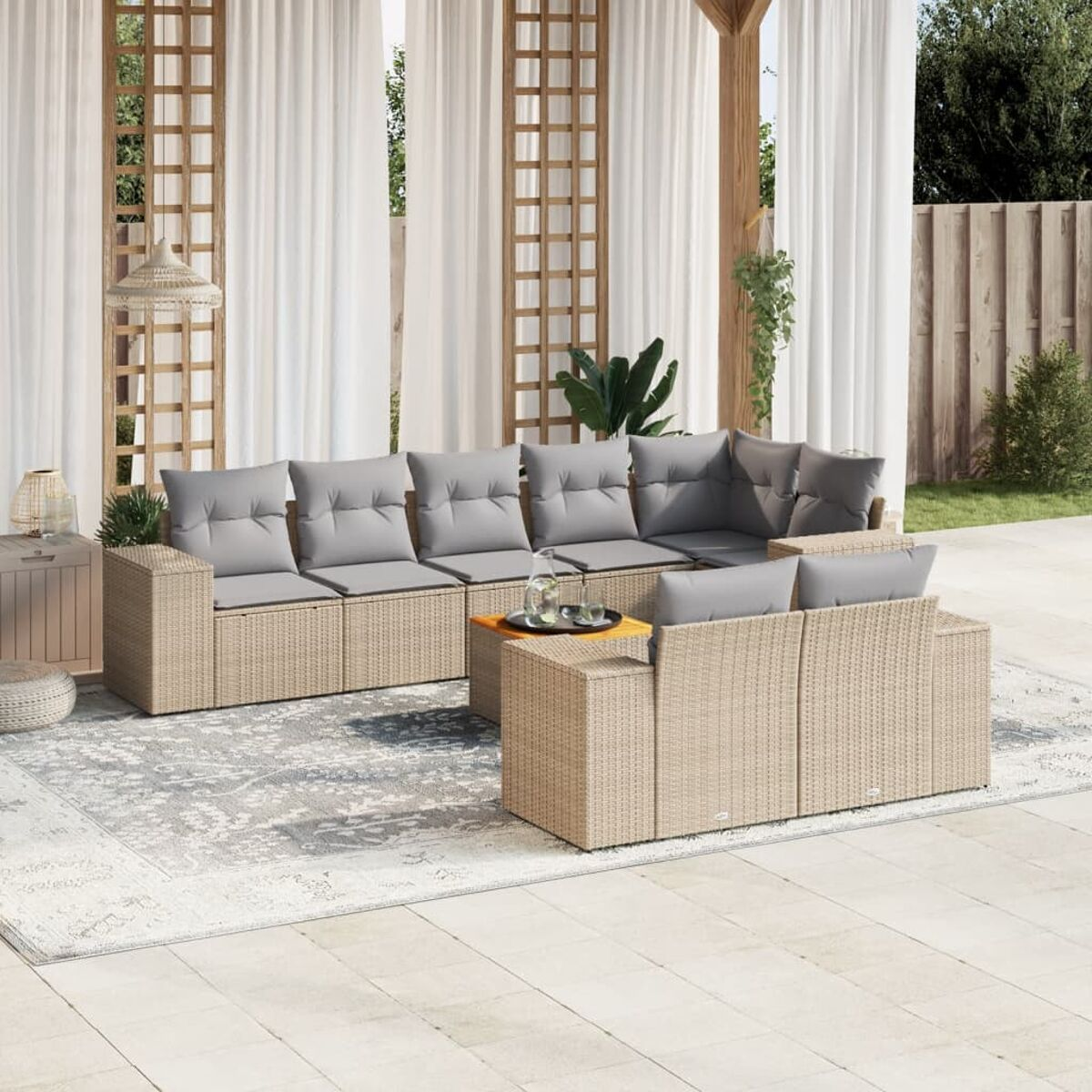 Beiges Outdoor-Ecksofa aus Korbgeflecht mit grauen Kissen und kleinem Holztisch auf Terrasse.