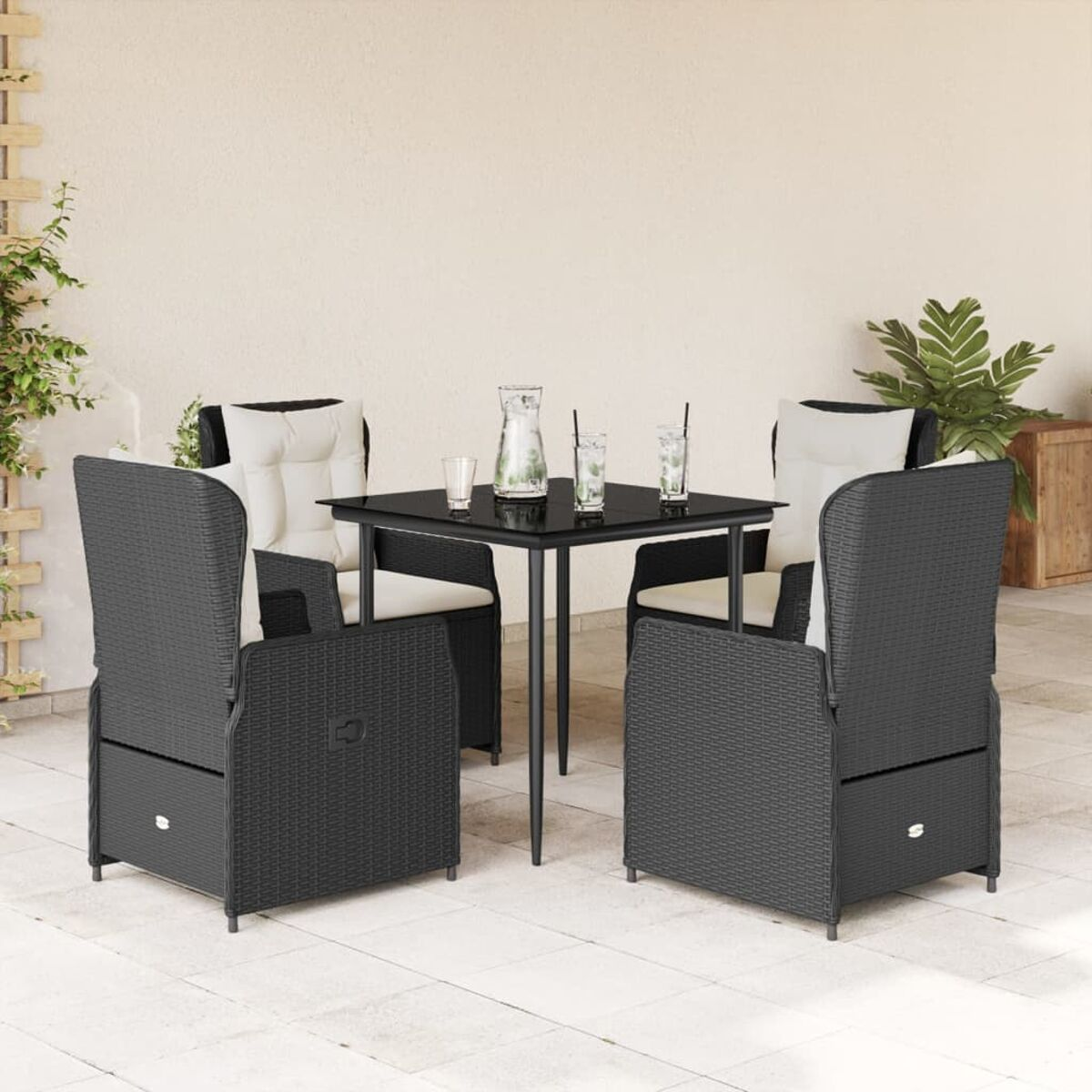 Tavolo da esterno con quattro sedie. Tavolo nero, sedie grigio scuro, con cuscini bianchi. Patio soleggiato.