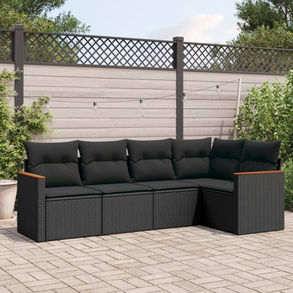 Ein schwarzes Outdoor-Ecksofa mit Holzarmlehnen, auf einer Backstein-Terrasse mit Pflanzen.