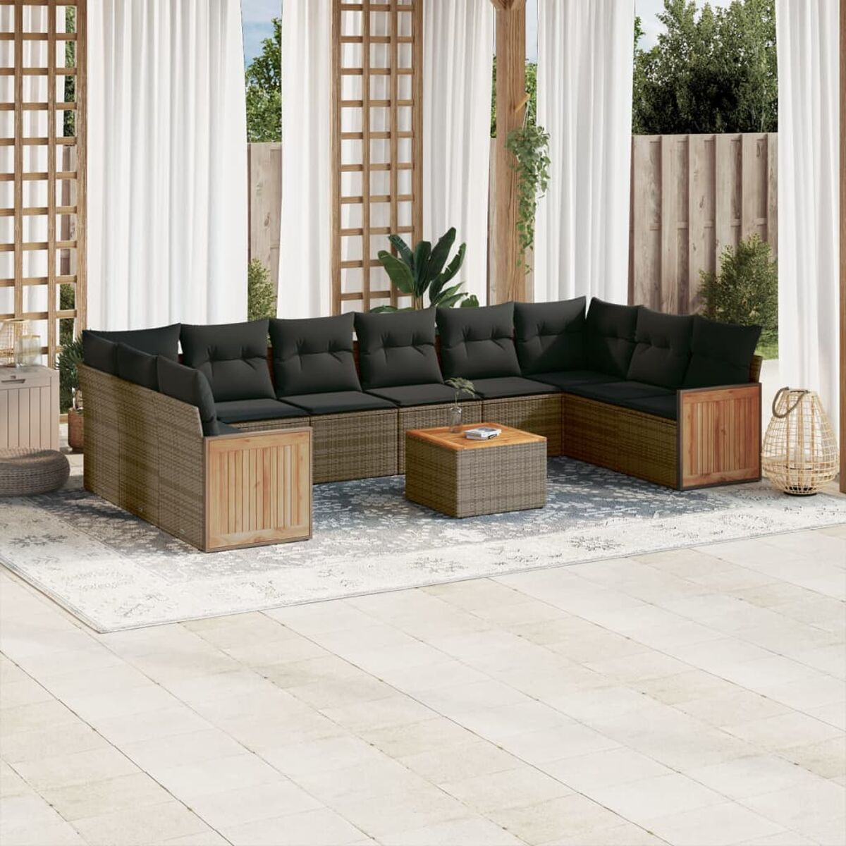 Korbmöbel-Set für den Außenbereich mit schwarzen Kissen und Holzakzenten, angeordnet auf einer Terrasse.