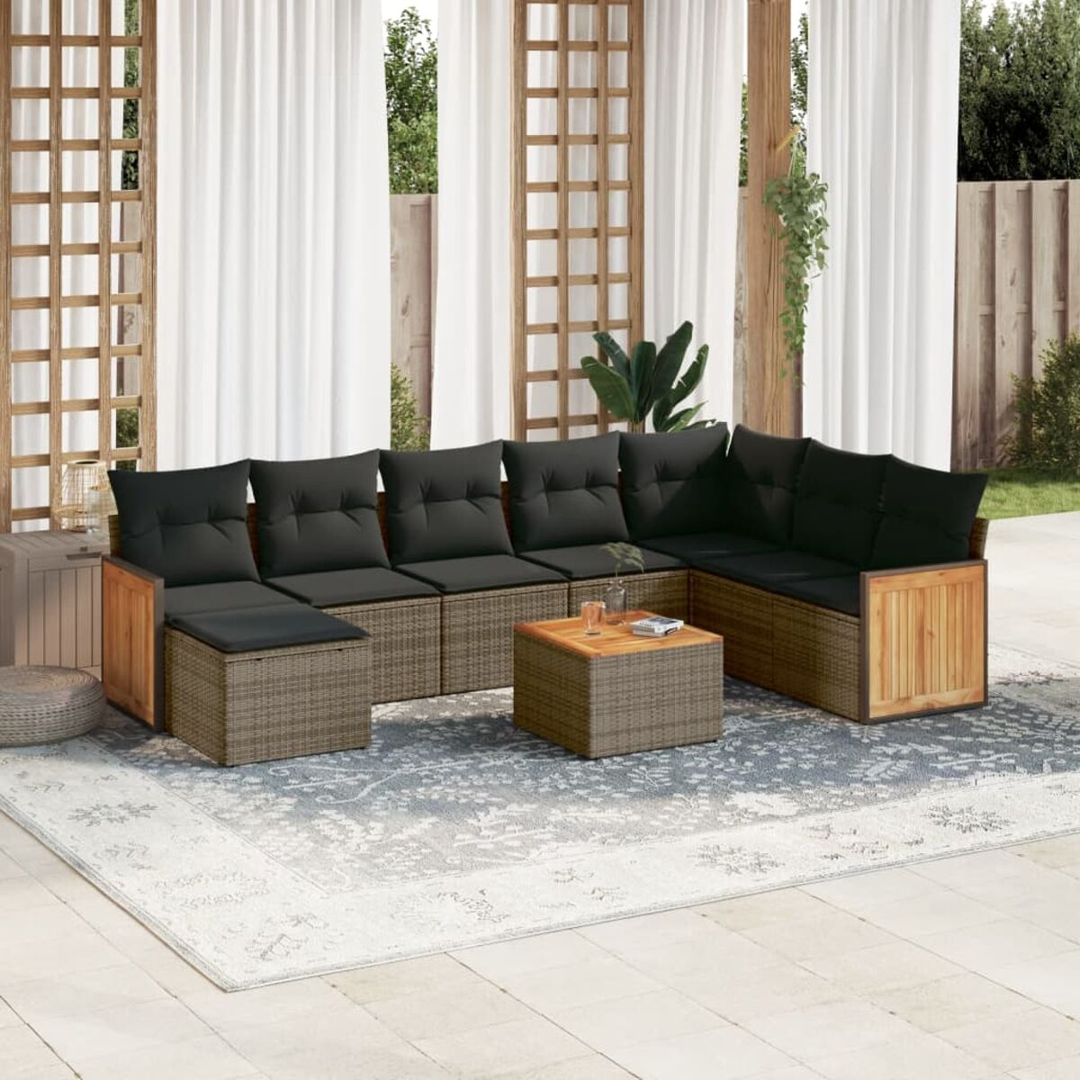 L-förmiges Rattansofa mit schwarzen Kissen und Holzakzenten. Ein Holztisch steht in der Mitte.