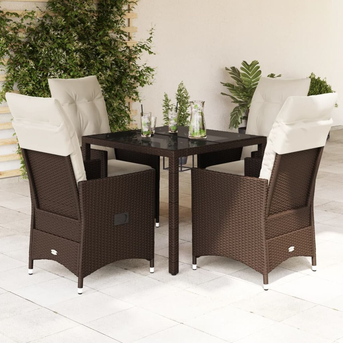 Essgruppe für den Außenbereich mit vier Rattan-Stühlen und einem quadratischen Tisch. Gläser und Pflanzen stehen auf dem Tisch.