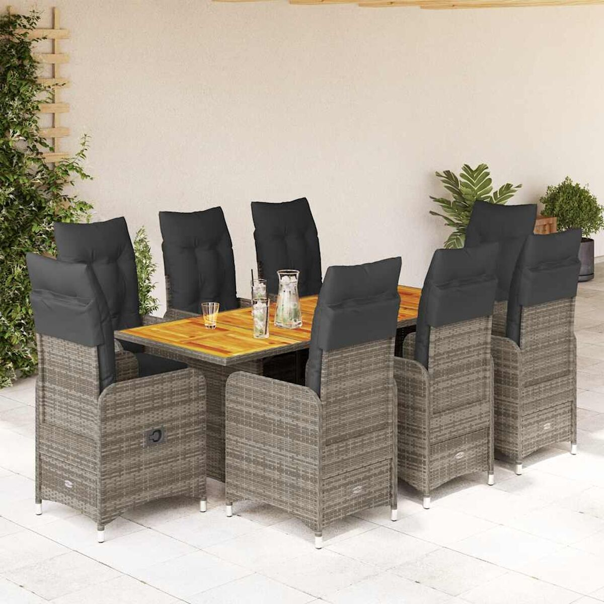 Essgruppe im Freien mit grauen Korbstühlen mit schwarzen Kissen, einem Holztisch und Glaswaren. Die Umgebung ist eine Terrasse.