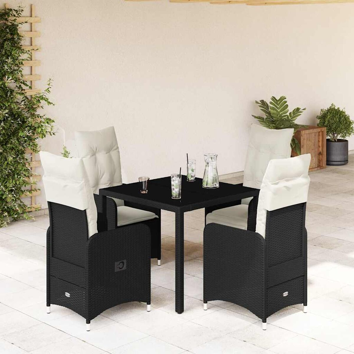 Un set da pranzo da esterno in vimini nero con quattro sedie e un tavolo quadrato su un patio.