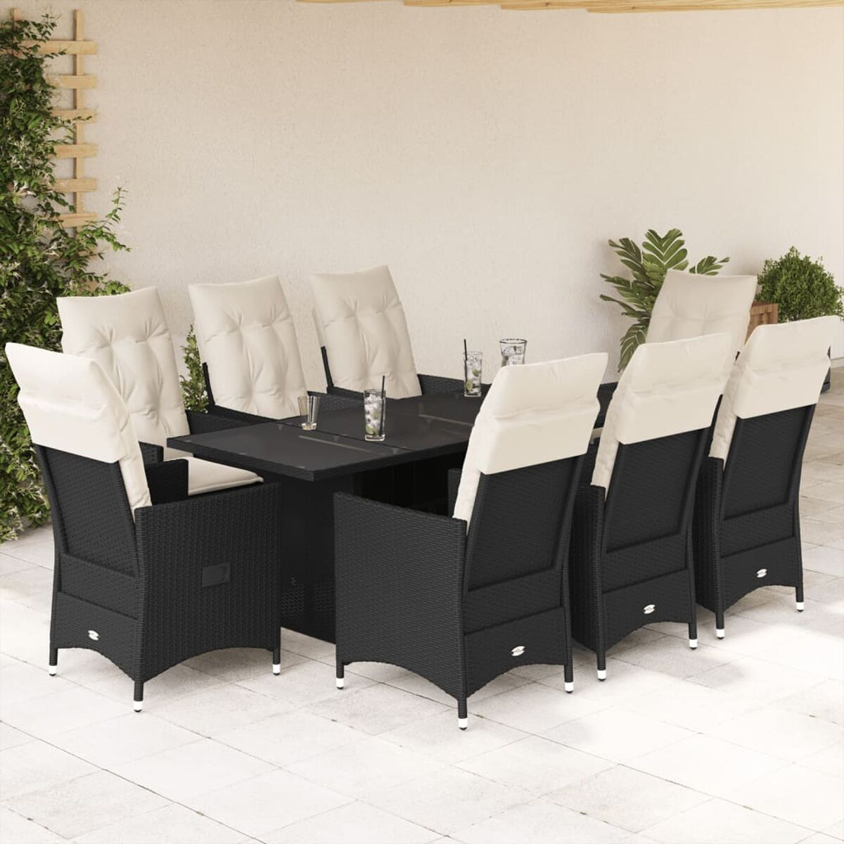Essgruppe im Freien mit schwarzen Korbstühlen, cremefarbenen Kissen und einem schwarzen Tisch. Getränke auf dem Tisch.